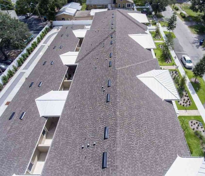 Aerial view of completed multi-family residential roof with asphalt shingles and skylights